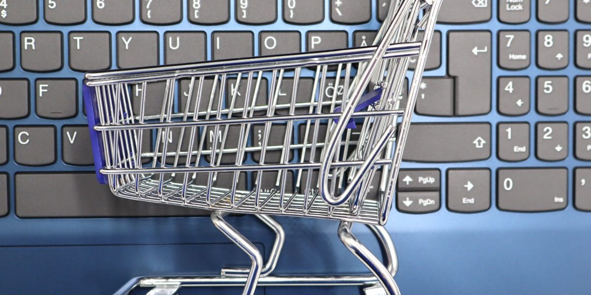 Dizüstü bilgisayar klavyesi üzerinde küçük bir alışveriş sepeti, e-ticaret kavramı